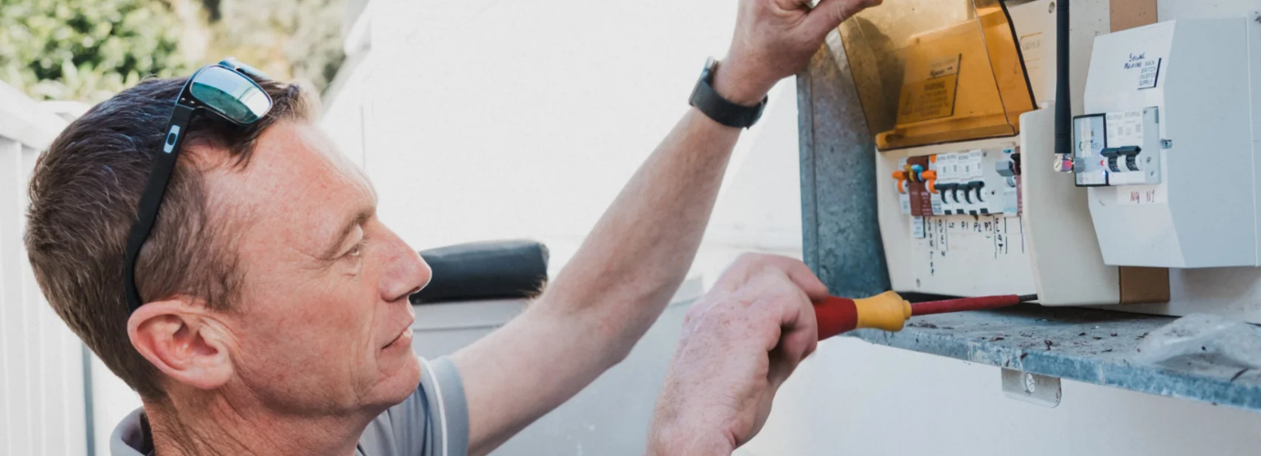 Img Alt Tag: Electrician checking an old switchboard before an upgrade in Sydney